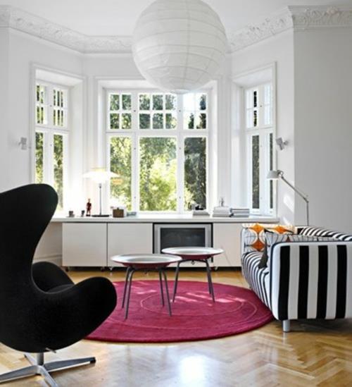 moderni televisio valkoinen olohuone pyöreä pehmeä vaaleanpunainen matto musta nojatuoli