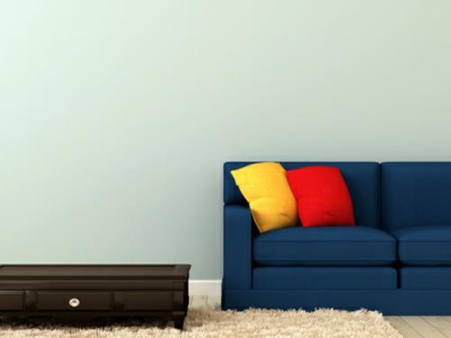 sininen sohva värikkäillä tyynyillä ja sohvapöydän koriste -elementeillä