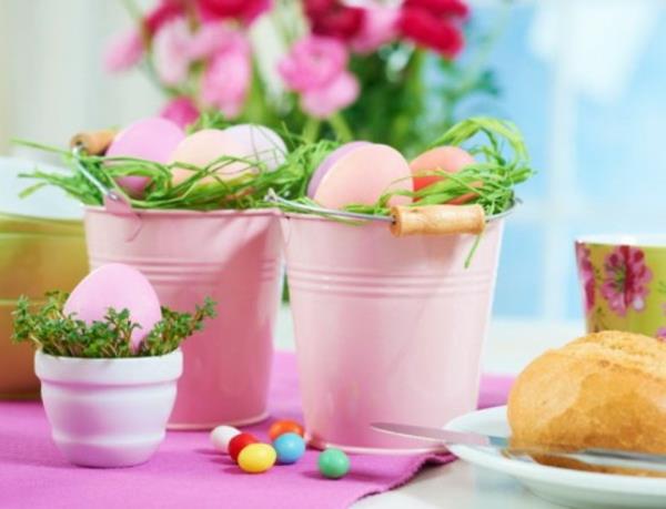 koristeellinen metallinen ämpäri täynnä vaaleanpunaisia ​​pääsiäismunia