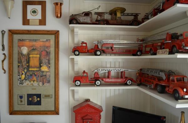 Kokoelma paloautojen vanhoja esineitä avoimilla hyllyillä