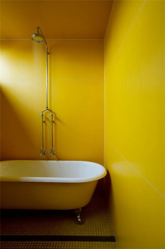 eklektinen talon sitruunankeltainen kylpyhuone, jossa on vapaasti seisova kylpyamme