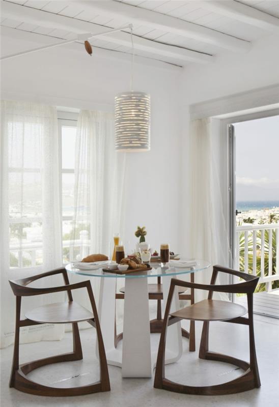 sisustusideoita ruokasali puiset tuolit pyöreä lasipöytä valkoiset seinät