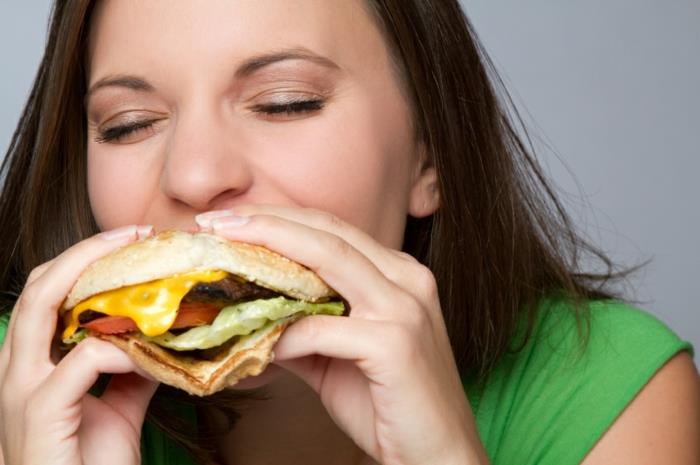 onnistunut laihtuminen nainen syö hampurilaista