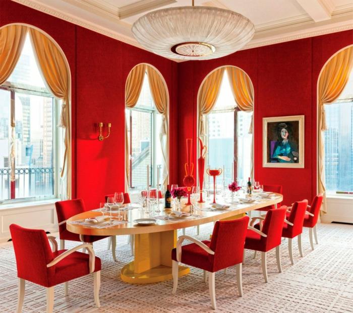Ruokasalin sisustus punainen seinämaali soikea ruokapöytä punaiset tuolit