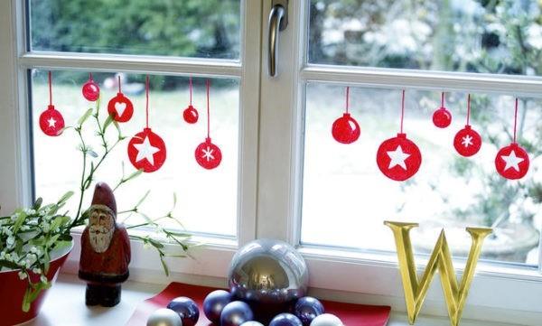 ikkunan koristelu adventtimaalatulla punaisella pallolla