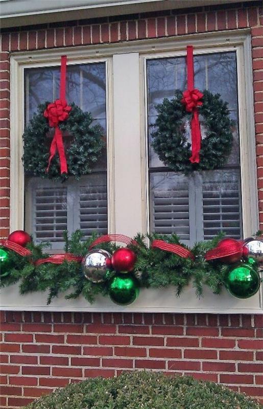 ikkunan koristelu jouluseppeleille punaiset jouset joulupallot
