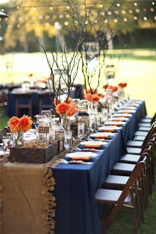 juhlapöydän koristeet tummansininen pöytäliina tyylikäs oranssi aksentti