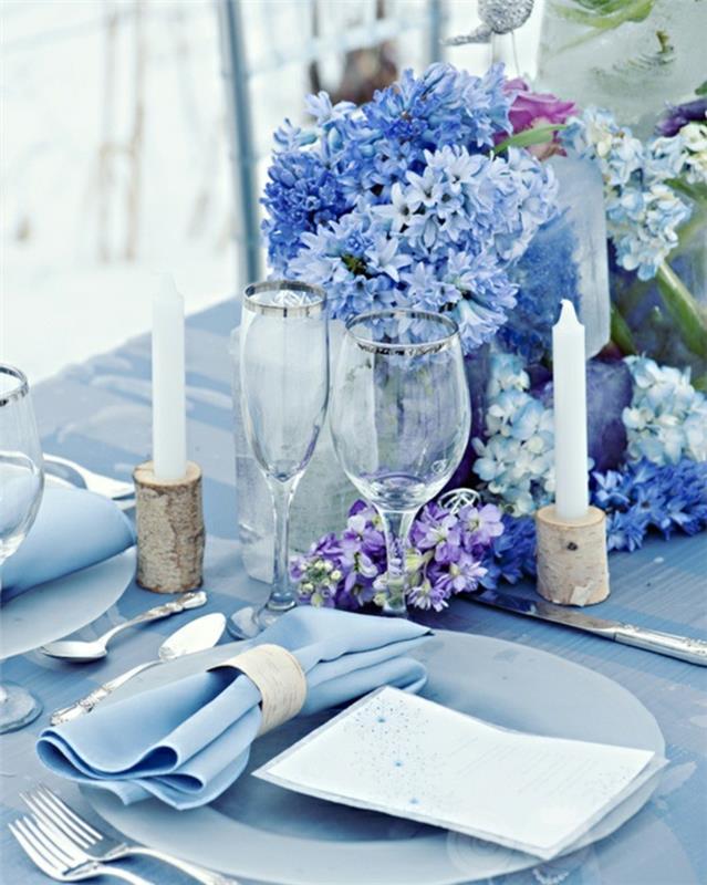juhlapöydän koristeet vaaleansininen pöytäliina kukkia kynttilät