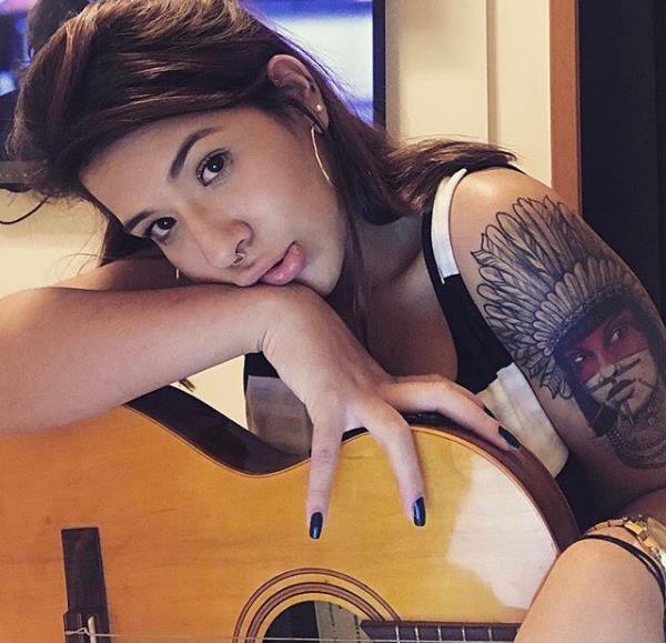 nainen, jolla on intialainen tatuointi kitaralla