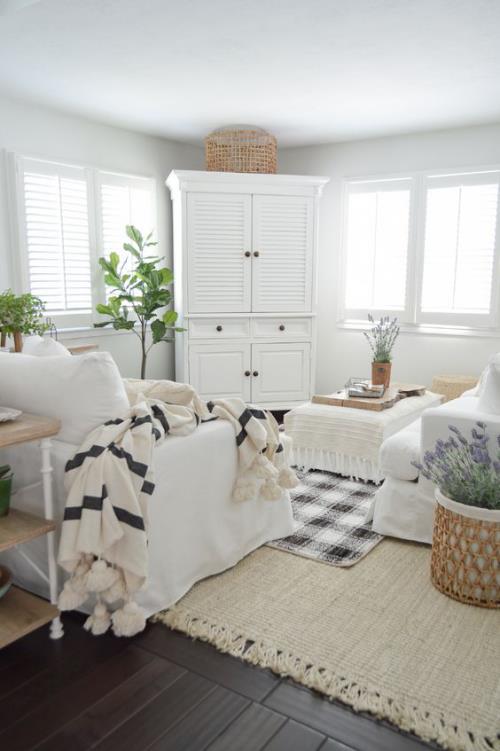 kevätmaiset sisustusideat olohuoneeseen maalaismaiseen tyyliin neulottu villapeite valkoiset kannet huonekaluista vihreät ruukkukasvit laventeli ruukussa