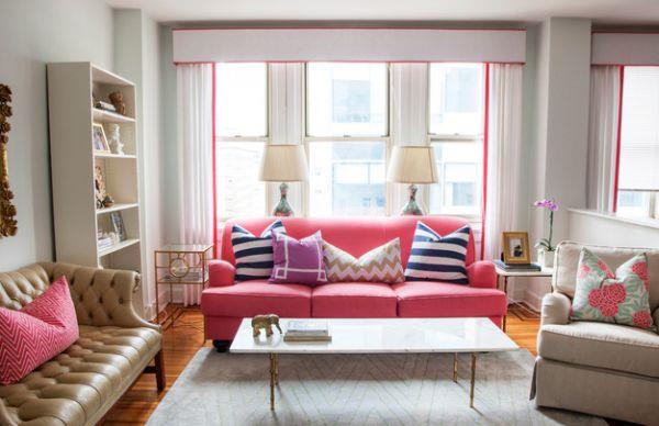 vaaleanpunainen sohva tuo tuoreita aksentteja lukuisiin kuvion tyynyihin