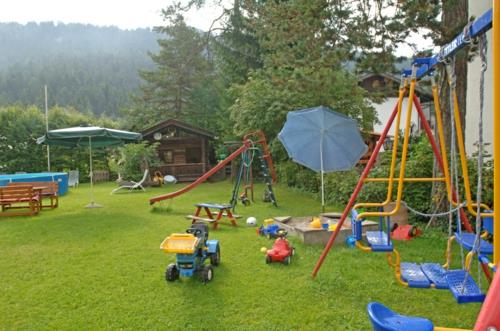 puutarha lasten leikkialue keinut liukumäki nurmikko pöytä penkki sateenvarjo