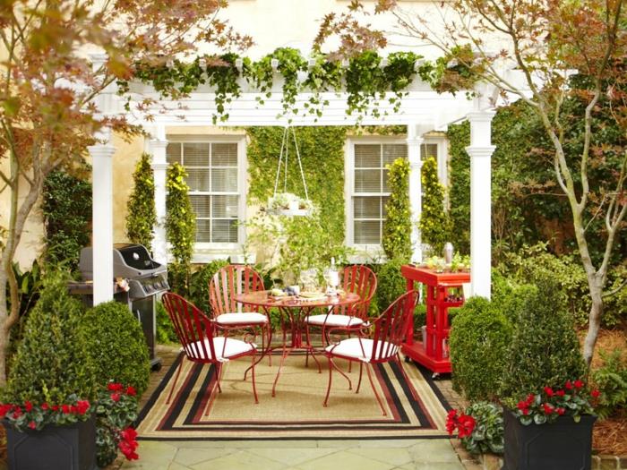 ideoita puutarhasuunnittelu pyöreä puutarhapöytä punainen puutarhakasvi matto