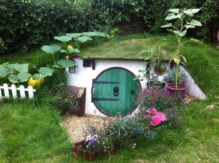 rakentaa puutarhavaja itse hobbit pyöreä ovi puu ruoho kukat kurpitsa