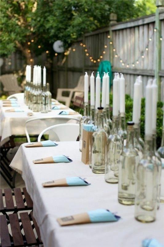 puutarhajuhlat ulkona pöydän koristelu lasipullot valkoiset kynttilät