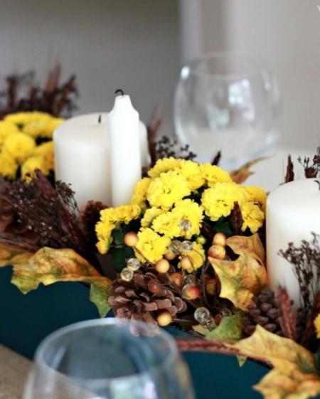 keltaiset krysanteemit valkoiset kynttilät männynkävyt pöytäkoriste syksyllä