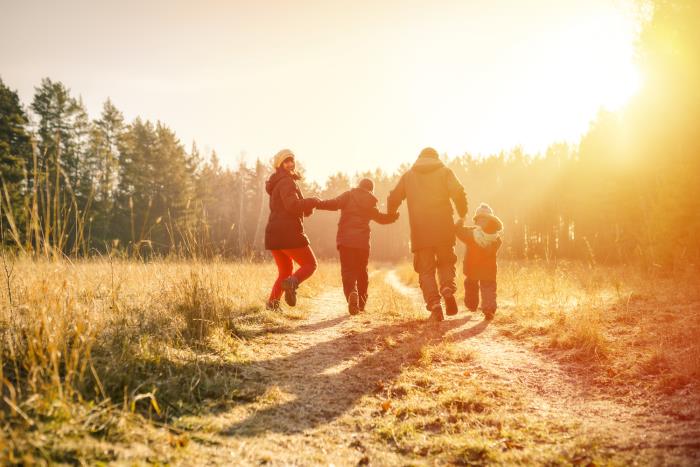 pysy terveenä ja onnellisena talvella koko perhe kaksi lasta lähtevät kävelylle aurinkoisena talvipäivänä