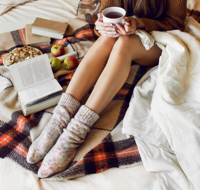 terve ja onnellinen talvella nuori nainen pysyy sängyssä pienet karkit omenat kuuma tee miellyttävä kodikas ilmapiiri