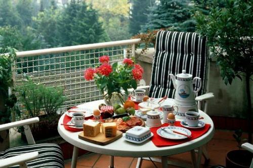 ruudukko parveke kodikas pyöreä pöytä raidat mustat valkoiset kukat punainen aamiaispöytä