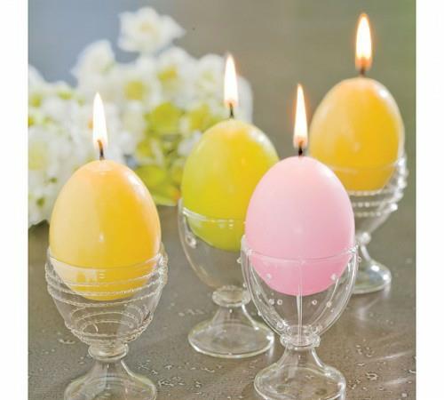 hehkuvat kynttilät värikkäästi maalatut pääsiäismunat munanpidike muovia