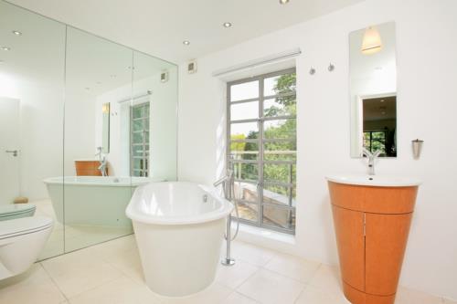 hyvin suunniteltu kylpyhuone laatta kylpyamme peili seinä pesu kaappi