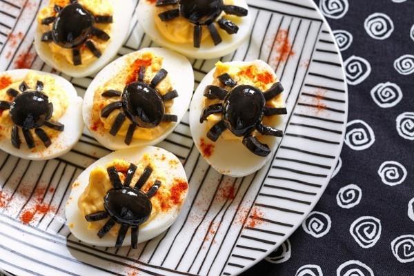 Halloween -sormiruokaideat oliiveista ja munista tekevät pieniä hämähäkkejä itse
