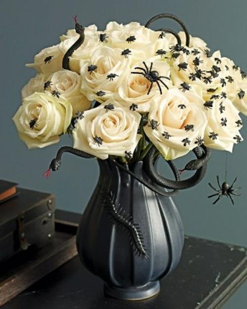 halloween -pöydän koristelu valkoisia ruusuja ja koriste -hyönteisiä
