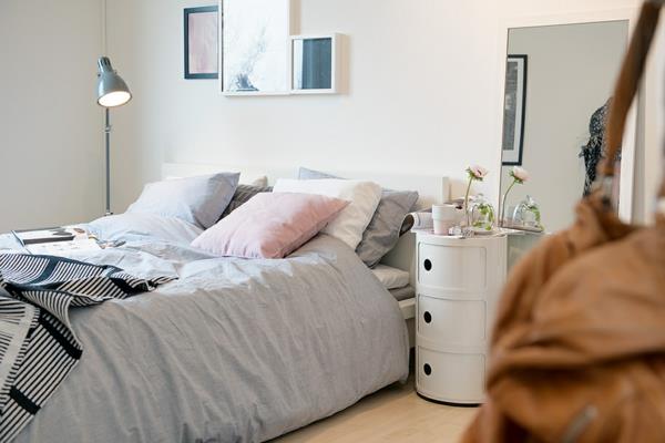 valoisa ja mukavasti kalustettu huoneisto lattiavalaisin vuodevaatteet