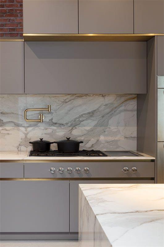 integroitu liesituuletin tyylikäs keittiömuotoilu harmaa marmori pienet kultaiset aksentit