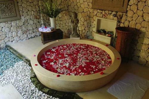 mielenkiintoinen kylpyhuone suunnittelu kivi karkea kylpyamme ruusun terälehtiä