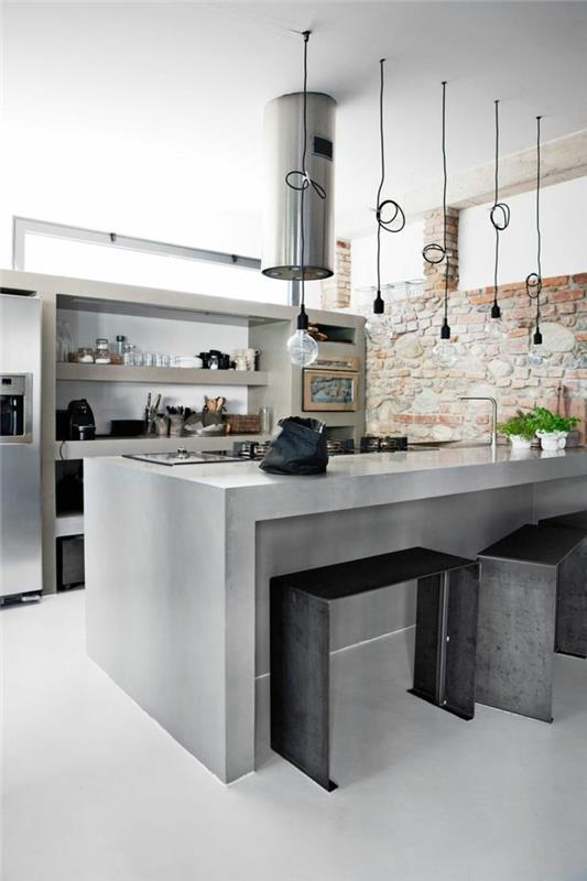 Keittiössä betoninen keittiösaari ja metalliset elementit