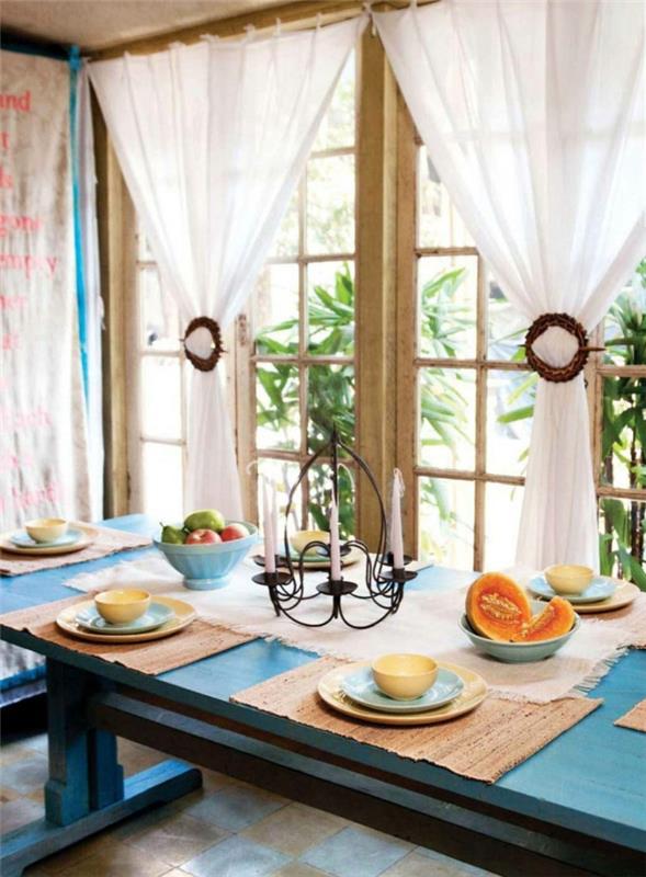 keittiön suunnittelu keittiöikkuna valkoiset verhot puutarhapidike ruokapöytä sininen maalaismainen