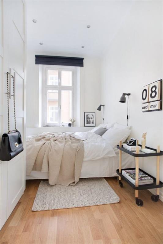 pieni makuuhuone yksinkertainen skandinaavinen muotoilu valkoinen dominoitu pöytä pyörien kalenterissa seinällä
