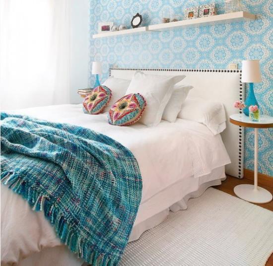 pieni makuuhuone visuaalisesti laajentaa sinivalkoisia koristetyynyjä, joissa on etnisiä kuvioita