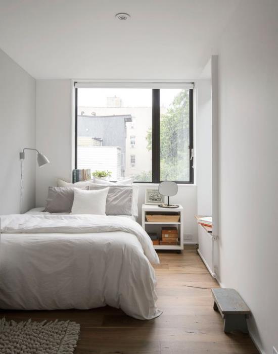 pieni makuuhuone visuaalisesti laajentaa iso ikkuna nukkuva sänky yöpöytälamppu yksinkertainen sisustus