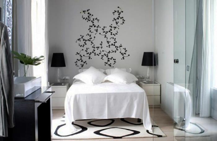 makuuhuoneen sisustus valkoiset yöpöydät seinätarrat mustat pöytävalaisimet