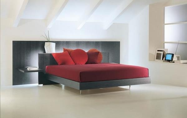 mukava sänky, jossa on tyylikkäät tulipunaiset tyynyt ja viininpunainen pussilakana