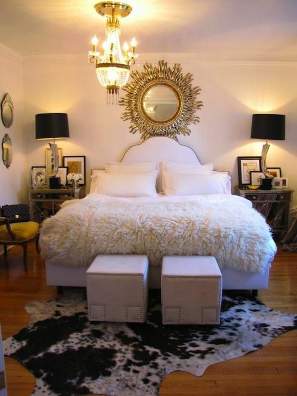 Ruskean ja valkoisen lehmännahan maton asettaminen makuuhuoneen sängynmattoihin