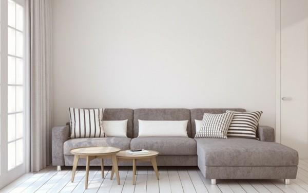 Skandinaavinen sisustus, jossa on verhoiltu sohva ja pyöreät sohvapöydät