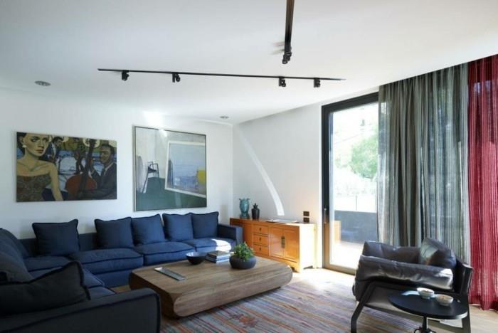 valaisimet olohuoneen valaistusideat tummansininen sohva puinen pöytä raidallinen matto seinäkoriste
