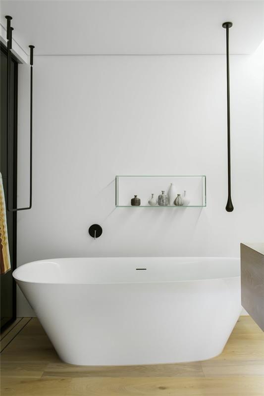 ylellinen minimalistinen kylpyhuone, jossa on vapaasti seisova kylpyamme