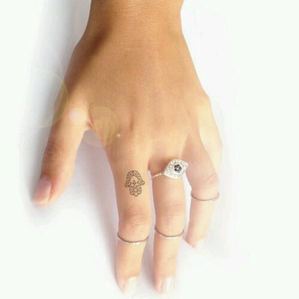 mini hamsa tatuointi sormella