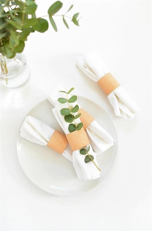 minimalistiset lautasliinarenkaat, jotka on valmistettu wc -rullista ja joissa on eukalyptuslehtiä
