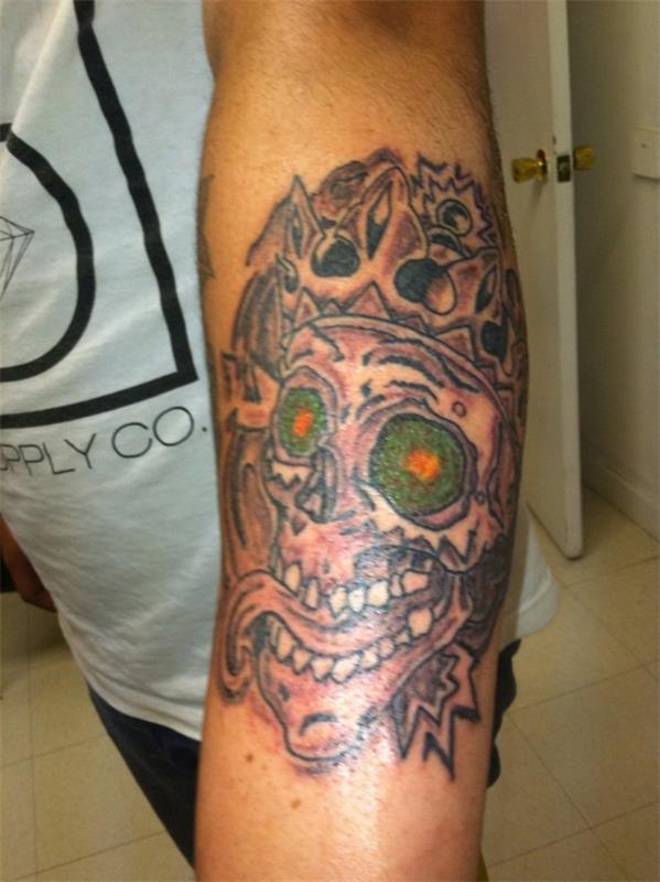 tatuointi olkavarren ideoita kallo vihreät silmät