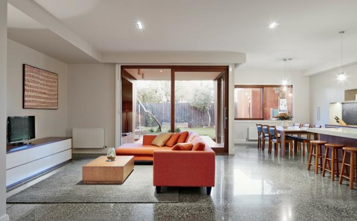 moderni sisustus avoin suunnitelma oranssi sohva harmaa matto keittiöeriste