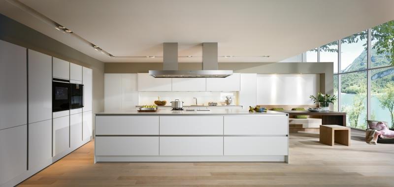 moderni keittiö valkoinen keittiösaari kiiltävä puulattia