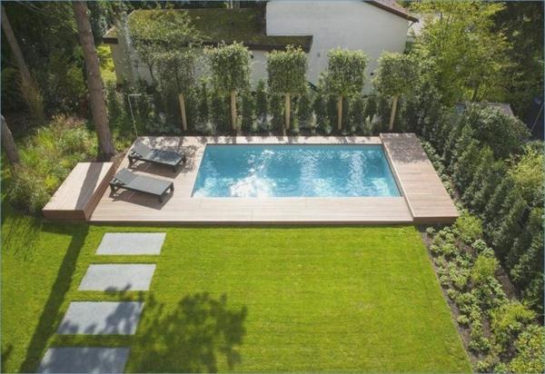 moderni puutarha uima -altaalla vihreä nurmikko aurinkotuoleja yksityisyysnäyttö