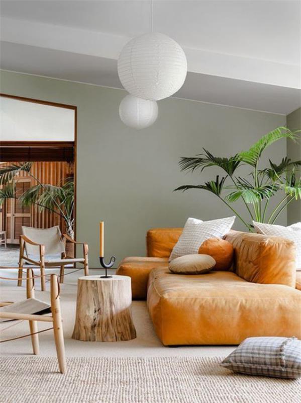 moderni olohuone valkoinen vaaleanharmaa hiekka nahkainen sohva luonnonmateriaalit puunrunko riippuvat valot vihreä kasvi ruukussa