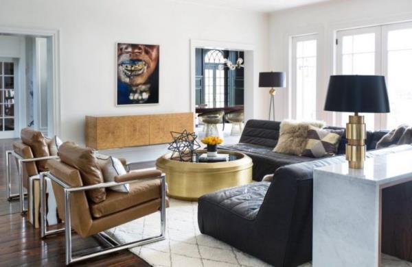 moderni olohuone eklektinen huonesuunnittelu nahkainen nojatuoli musta nahkasohva kiiltävä kultainen pyöreä pöytä keskellä seinämaalauksia liikaa värejä