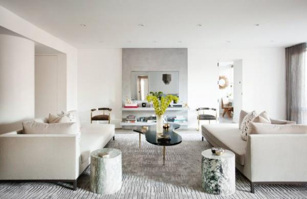 moderni olohuone geometriset muodot vaaleat värit kaksi sohvaa matto pieni musta sohvapöytä kaksi puunrunkojakkaraa